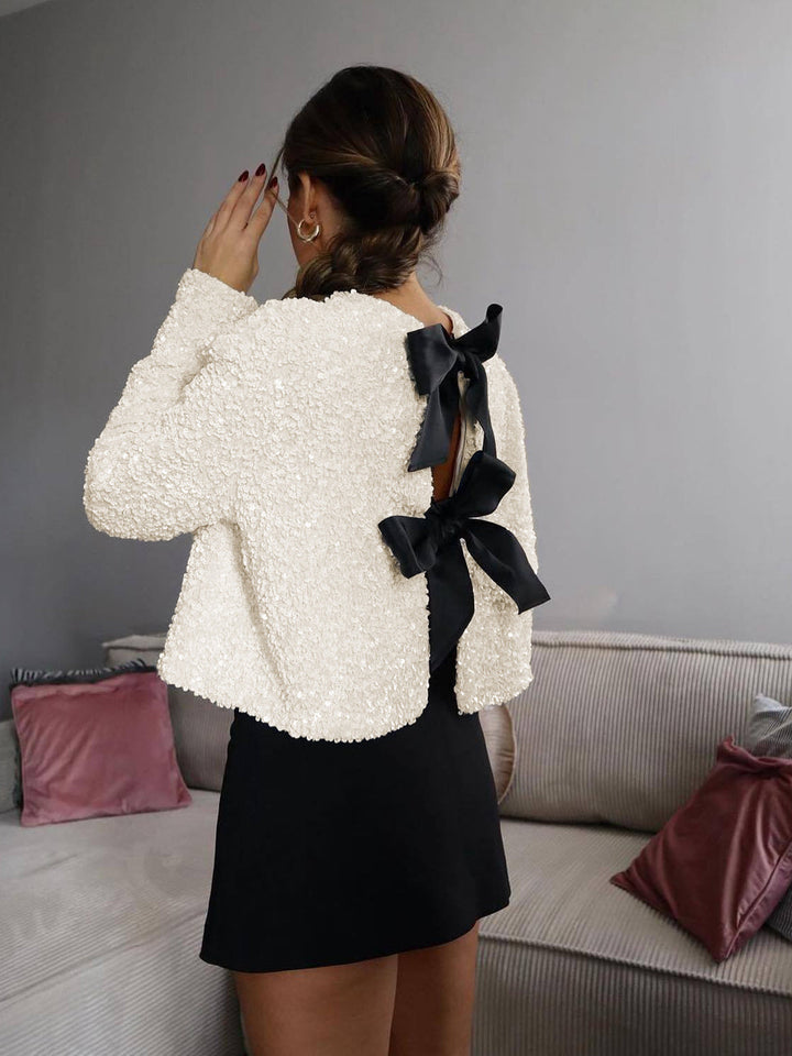 Glamorous women's cropped sequin cardigan with bow, ideal for special occasions & festive outfits.