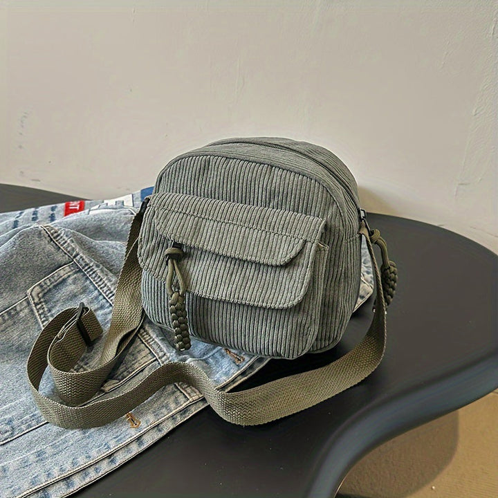 Vintage-style women's crossbody bag with a textured design and zip.