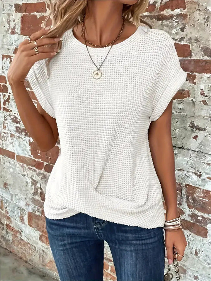 Close-up of a women's waffle knit top, showcasing the textured, soft, and breathable fabric.