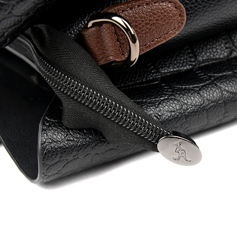 A woman's hand reaching into the open Sophia black leather tote bag for easy access.