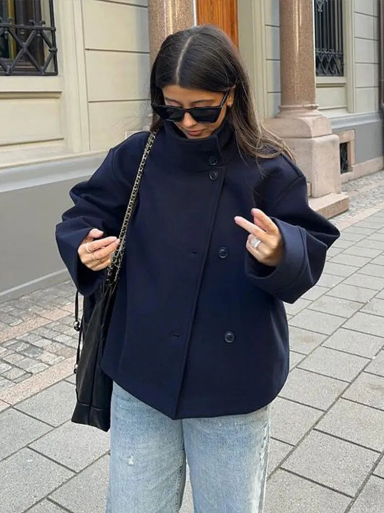 A woman wearing a warm, layered style pea coat with a sophisticated stand collar.