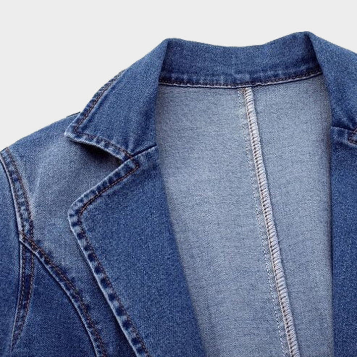 Close-up of women's blue denim blazer, showcasing polished tailoring and button detail