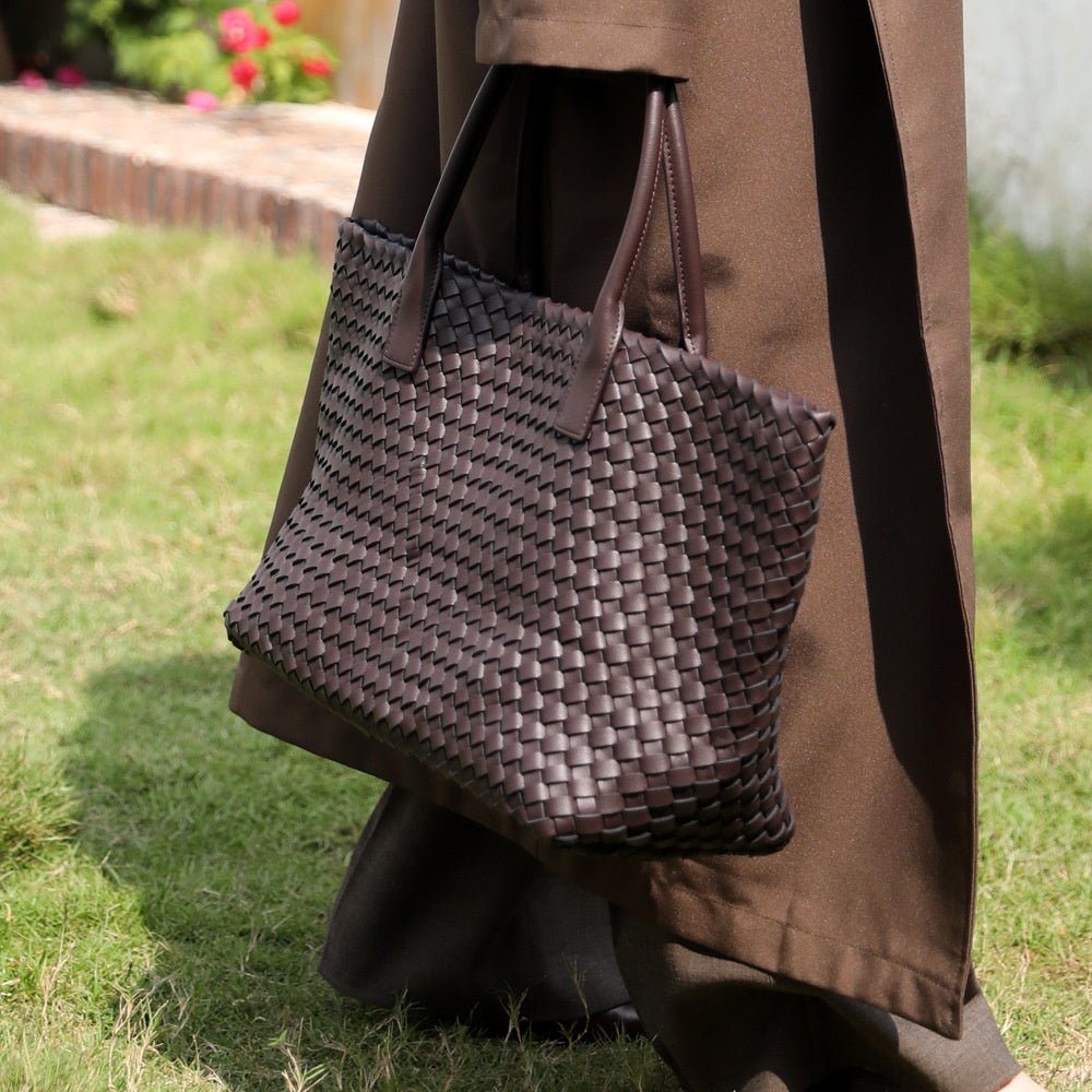 Black woven leather tote bag for women. Chic shoulder bag with spacious interior for essentials.