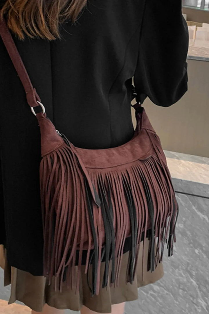Suede fringe detail cascading down a boho shoulder bag.