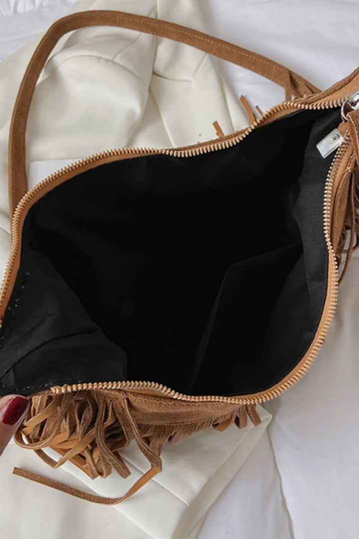 Detail of the adjustable strap on a women's suede crossbody bag.