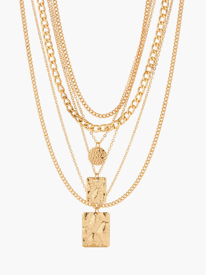 Elegant women's layered pendant necklace with unique textured charms. A versatile silver/gold fashion statement.