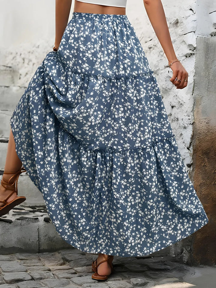A woman wearing a flowy, tiered floral maxi skirt, perfect for a stylish summer outfit.