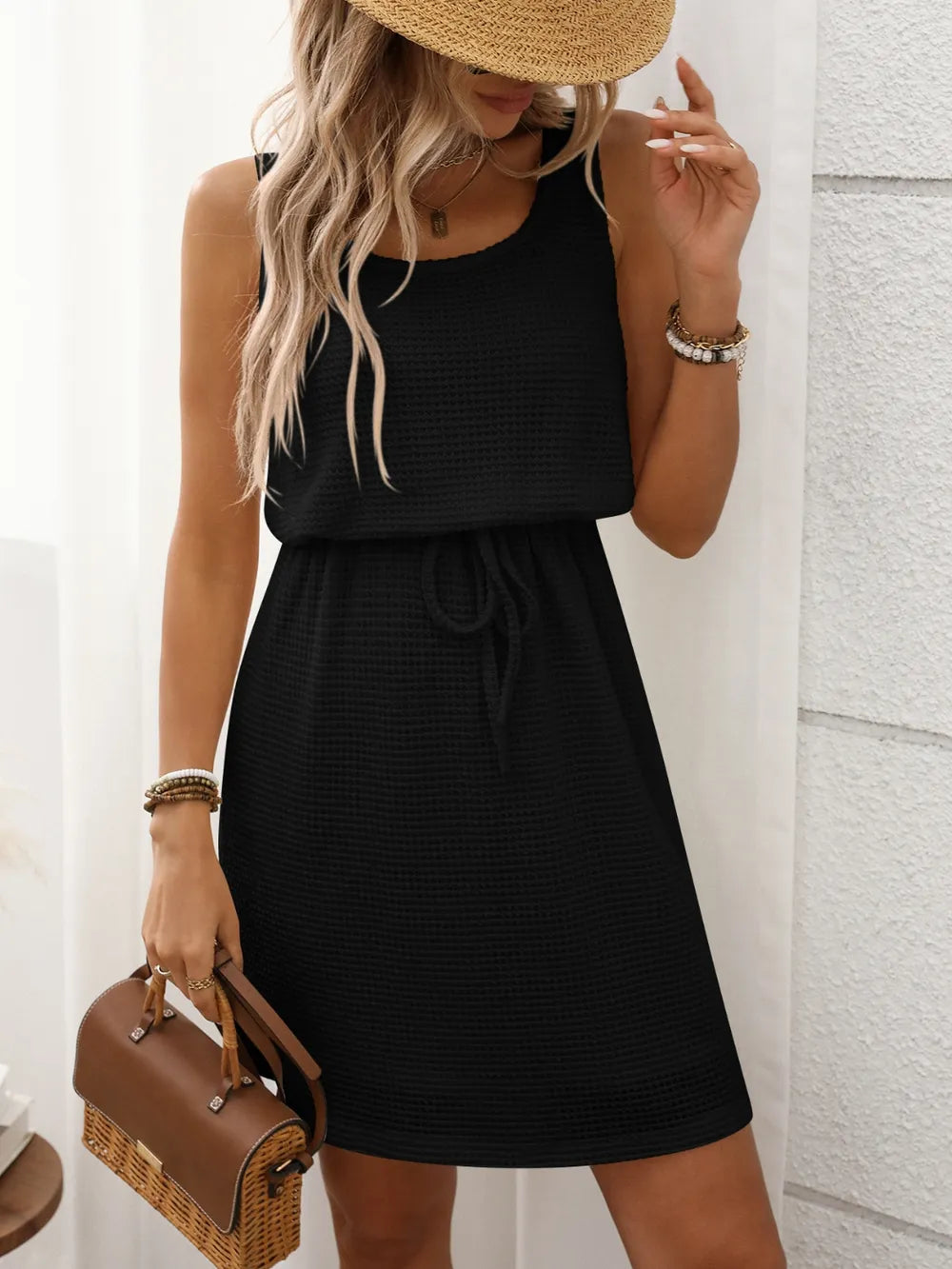 Detail of the drawstring waist on a women's waffle knit tank mini dress.