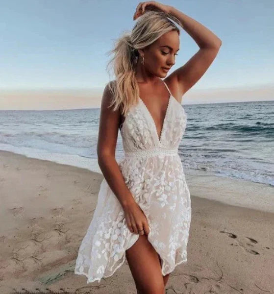 Women's white halter neck mini cocktail dress with floral embroidery, perfect for summer parties or wedding guests.