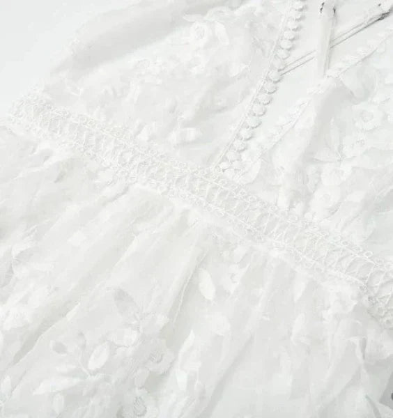 Elegant white women's halter neck mini dress featuring floral embroidery, a chic option for summer cocktail events.
