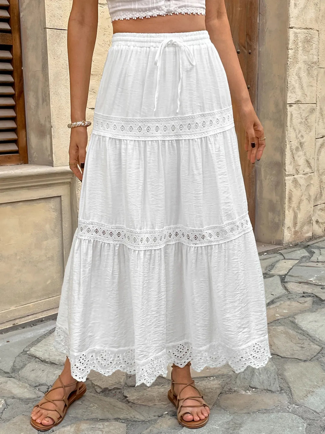 Women's white lace maxi skirt with adjustable tie waist for a bohemian summer look.
