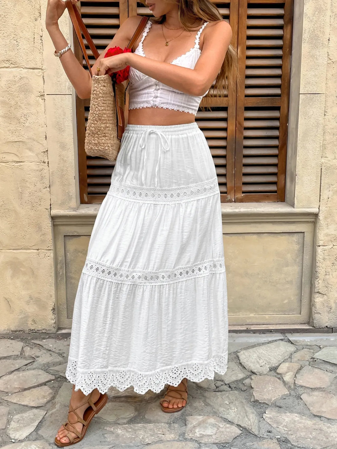 Feminine white lace maxi skirt with a charming tie waist, perfect for a casual yet chic outfit.