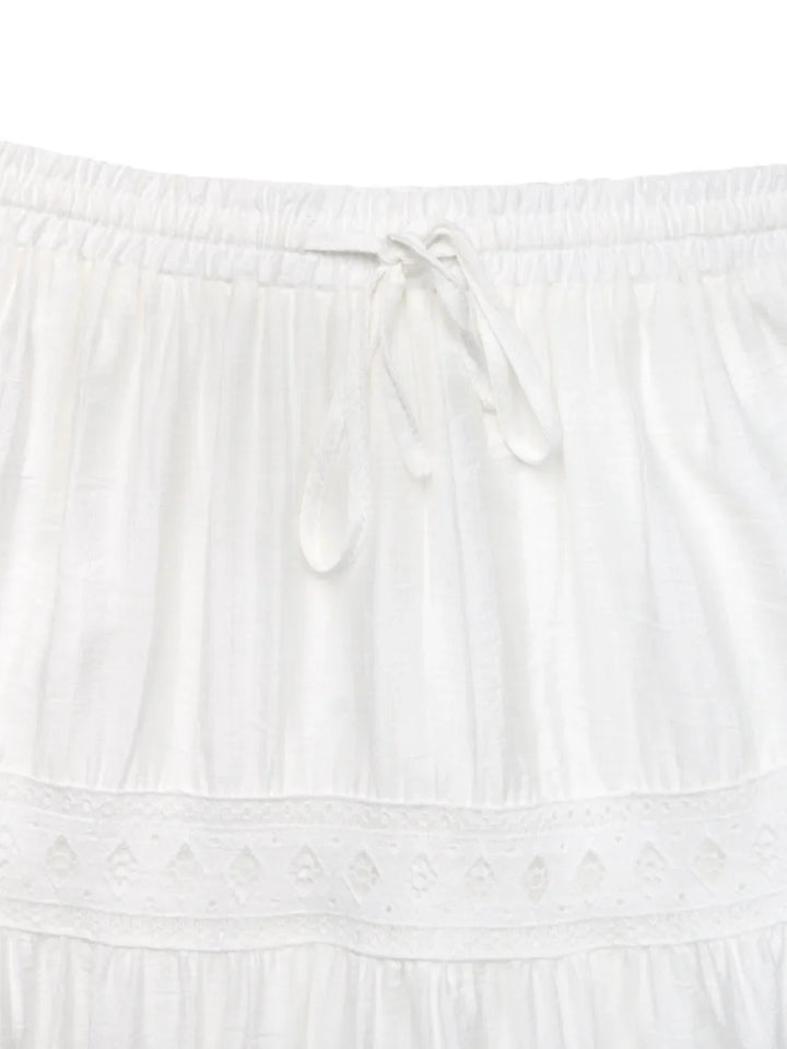 White lace maxi skirt with a relaxed fit and tie waist, embodying effortless summer style.