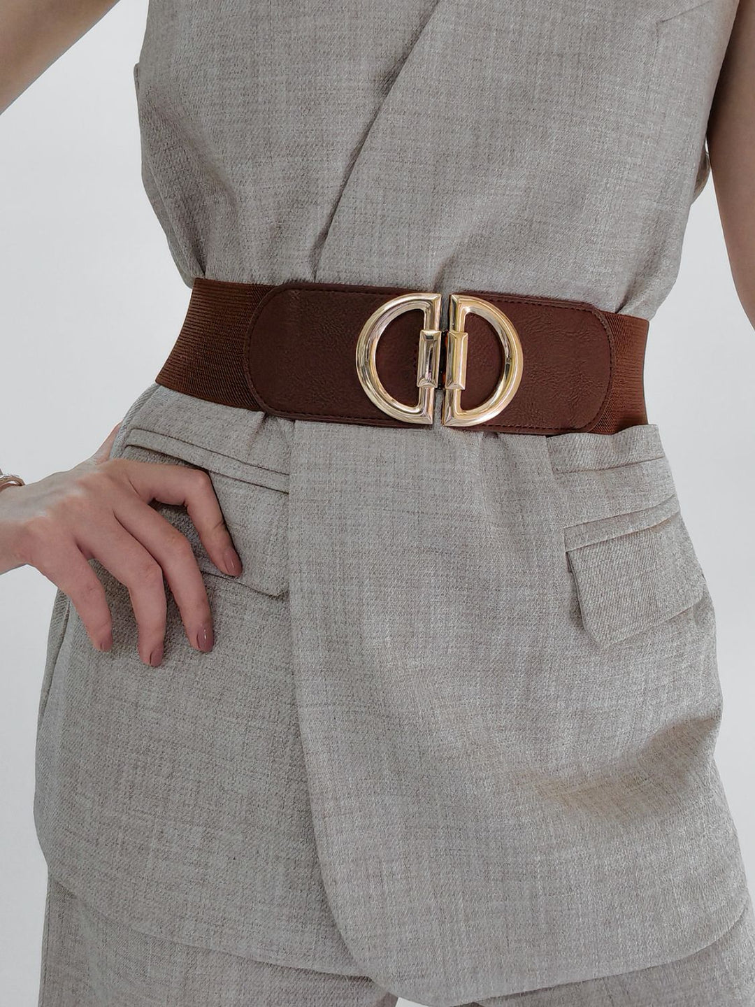 Stylish women's elastic cinch belt featuring a shiny gold buckle