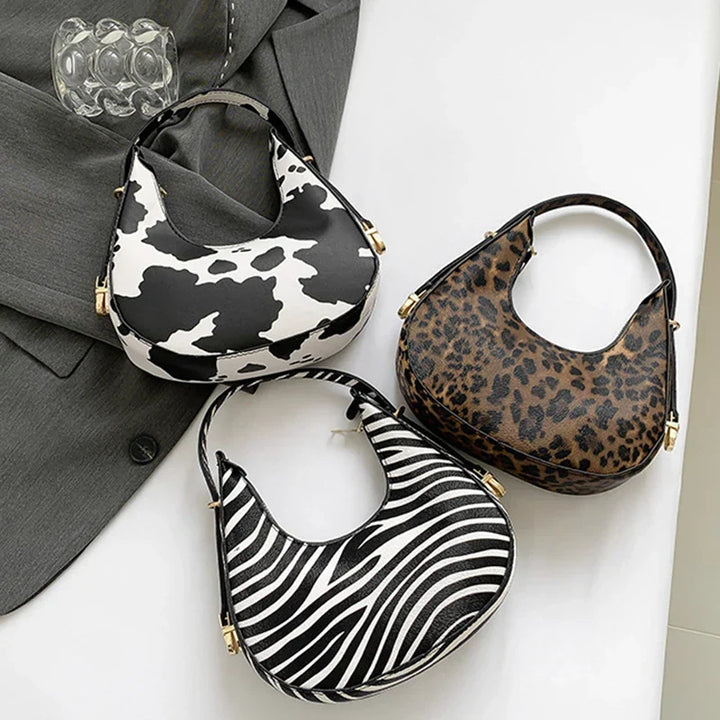 Luxury look animal print shoulder bag, women's faux leather crescent handbag, a zippered fashion accessory.