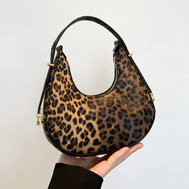 Faux leather animal print women's handbag, a stylish crescent shoulder bag with a functional zipper.