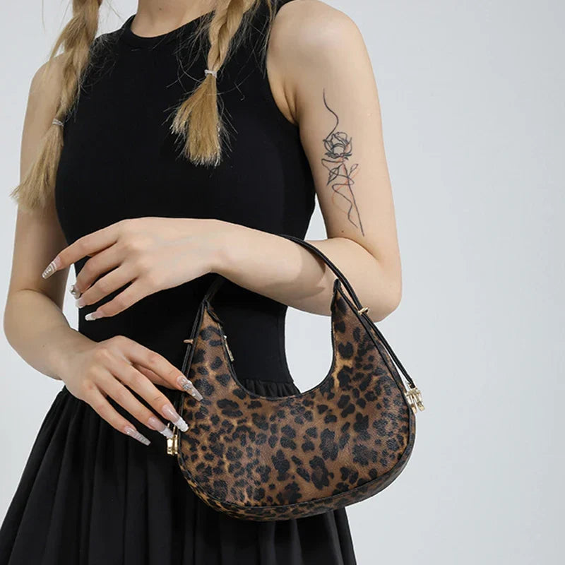 Modern women's animal print shoulder bag, faux leather crescent style, a zipped statement accessory.