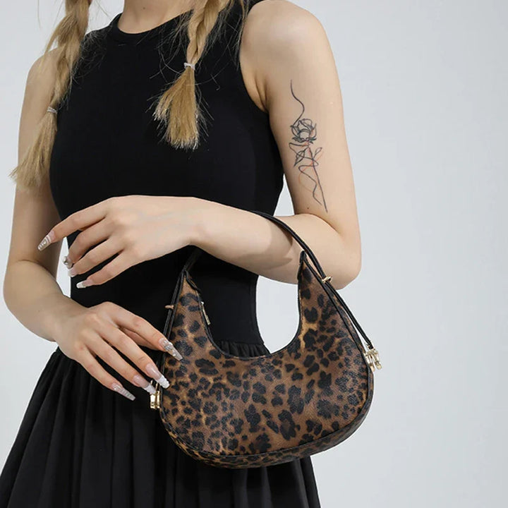 Modern women's animal print shoulder bag, faux leather crescent style, a zipped statement accessory.