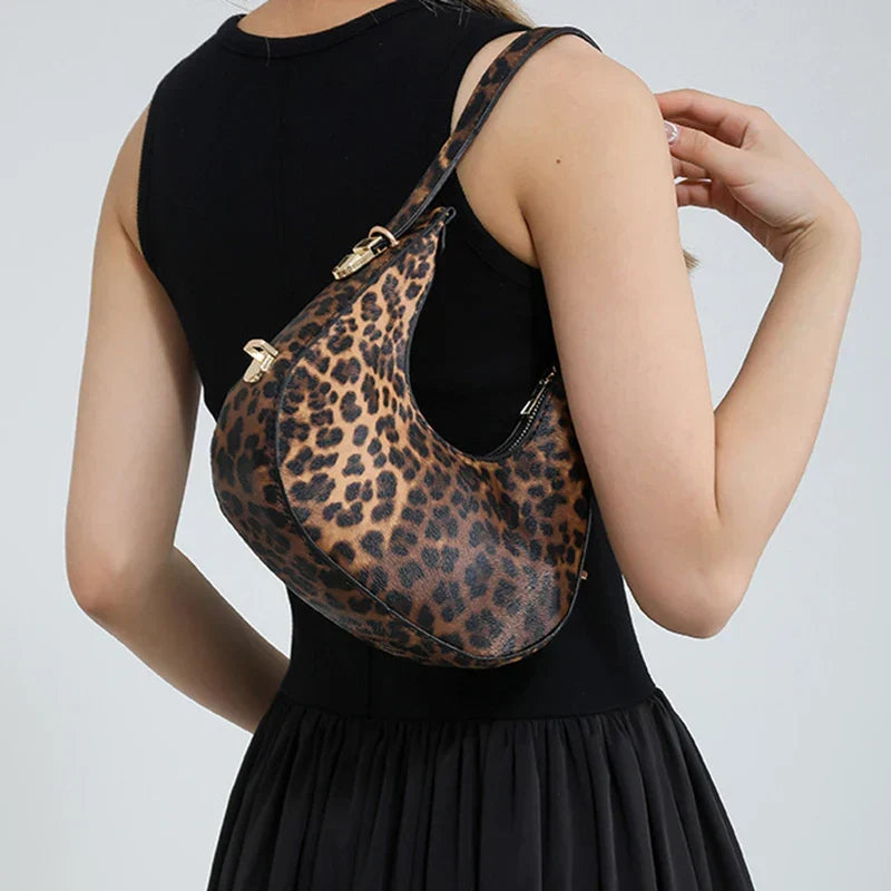 Elegant animal print women's shoulder bag, faux leather crescent handbag with a secure top zipper.