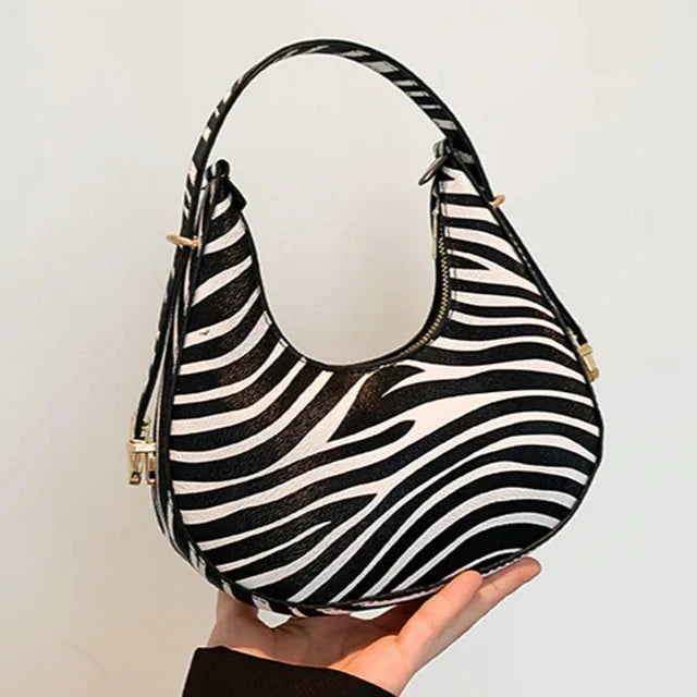 Fashionable animal print zipper bag for women, a versatile faux leather crescent shoulder handbag.