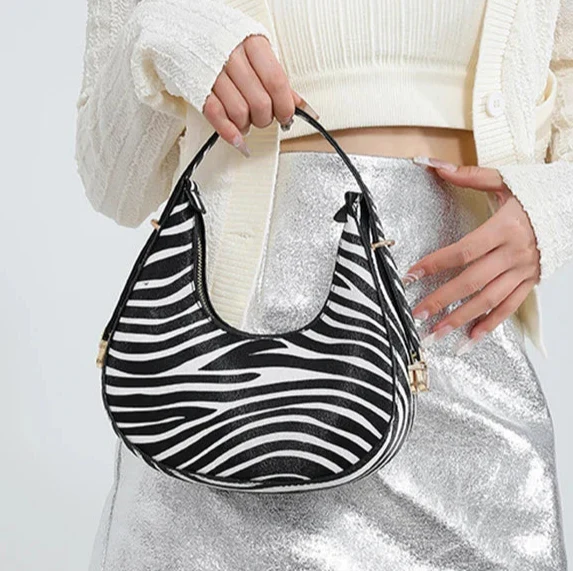 Bold women's animal print faux leather shoulder bag, a chic crescent handbag with practical zipper access.