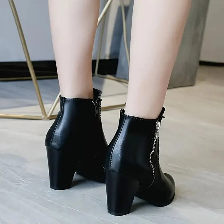 Fashion-forward black ankle boots for women, with a modern pointed toe, block heel, side zip & scalloped trim.