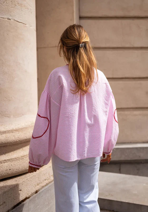 Stylish women's tie-front top featuring long sleeves and intricate ruffle details, perfect for any occasion.