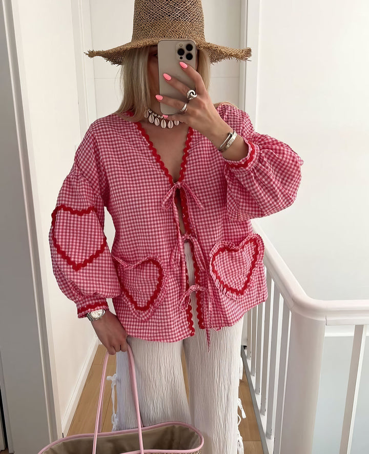 Fashionable women's blouse with long statement puff sleeves, tie front, and stylish ruffle details.