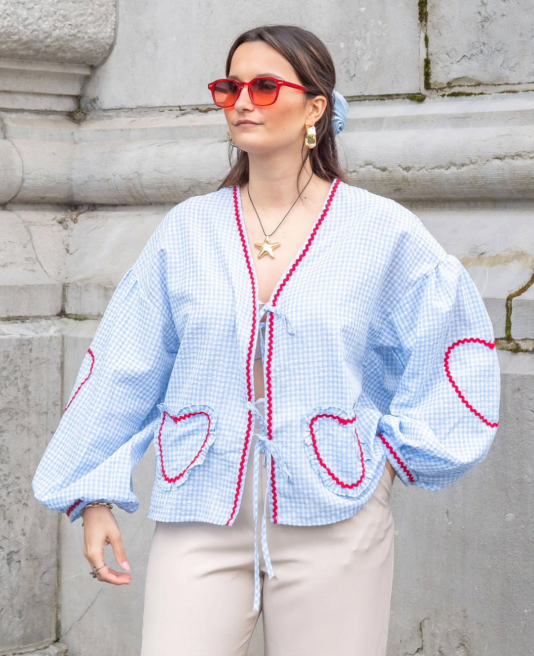Women's elegant long-sleeve tie-front blouse featuring chic ruffles and fashionable puff sleeves.