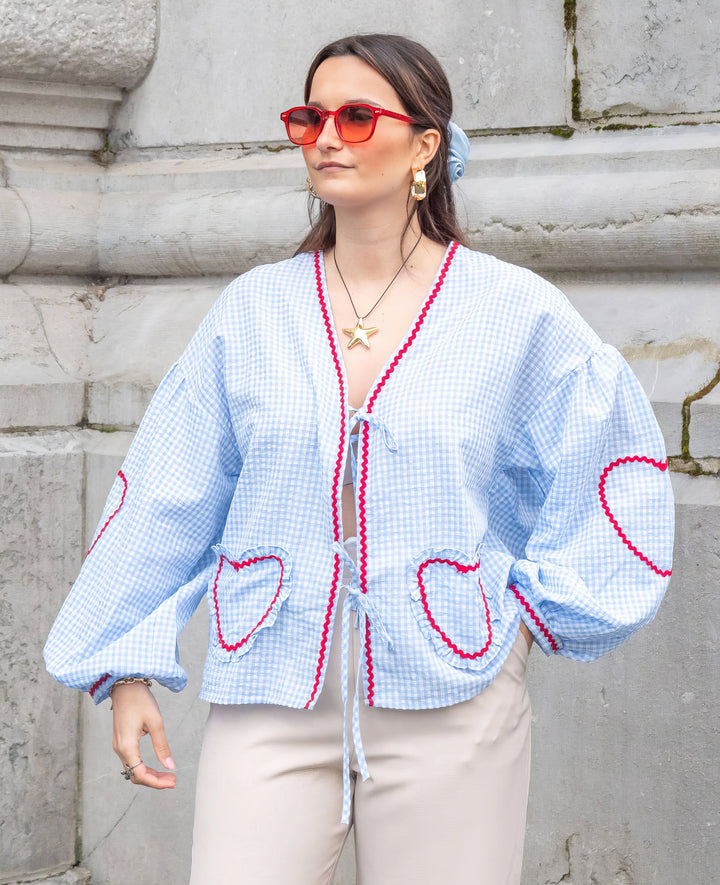 Women's elegant long-sleeve tie-front blouse featuring chic ruffles and fashionable puff sleeves.