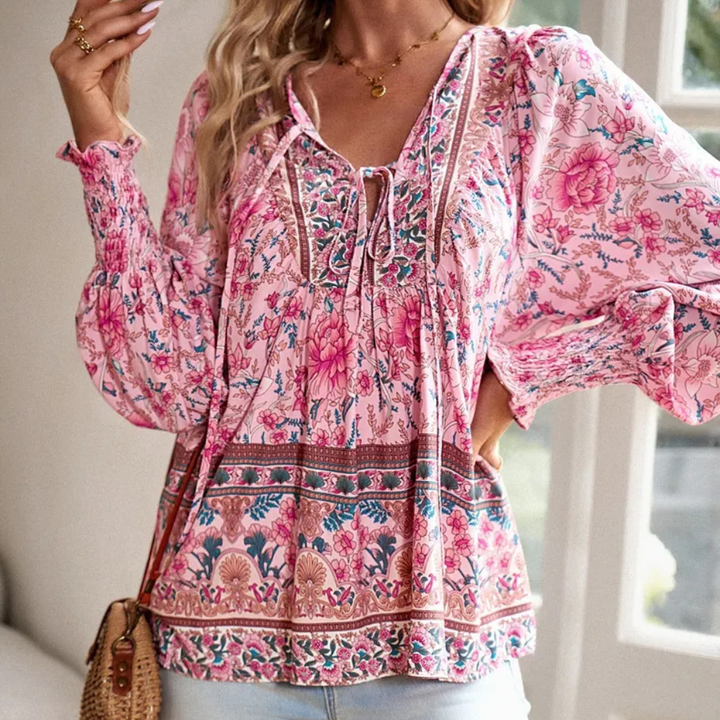 Chic women's long sleeve floral print blouse featuring a stylish tie neck & delicate smocked cuffs.