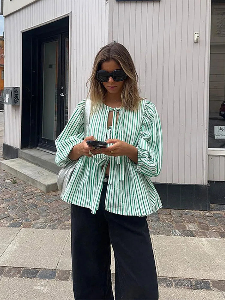 Stylish women's puff sleeve top, featuring a trendy tie front and peplum design.