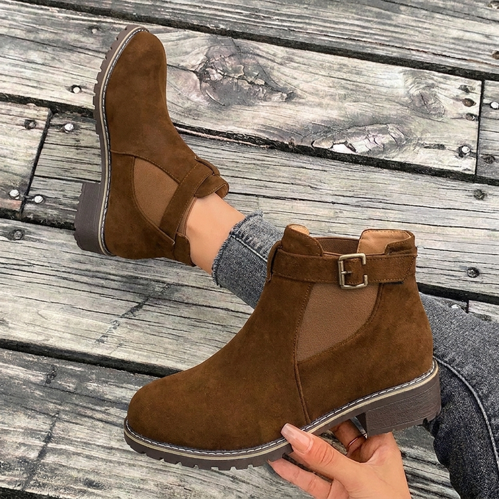 Versatile women's black Chelsea boots with a comfortable block heel and stylish buckle strap, suitable for any outfit.