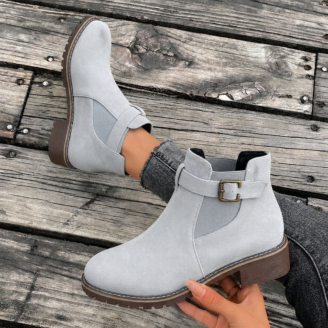 Fashionable women's grey Chelsea ankle boots, block heel, pointed toe, and buckle strap detail for a modern look.