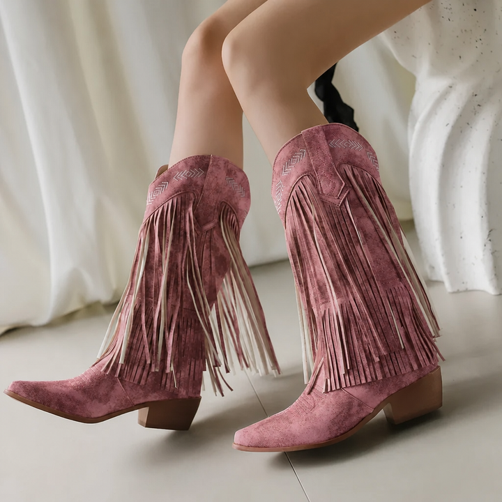 Close-up of white fringe cowgirl boots showing detailed western embroidery & block heel. Trendy women's boots.