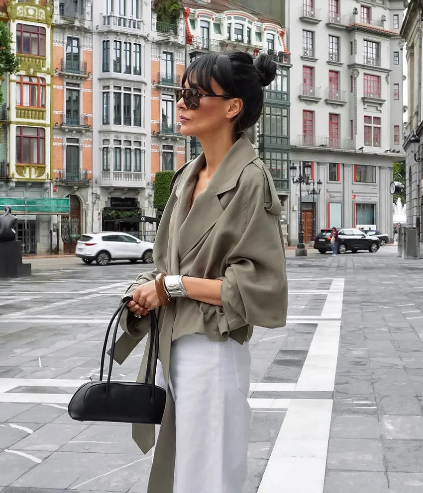 Stylish women's cropped trench coat, olive green, with a flattering tie belt & elegant notched lapel. Modern fall fashion.