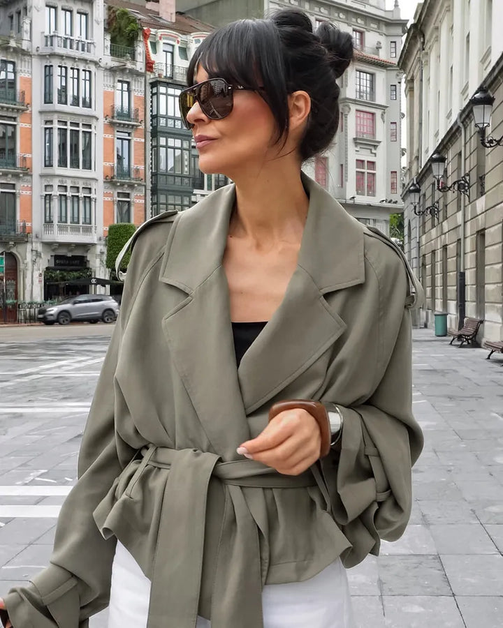 Statement olive green women's cropped trench jacket, detailed with a chic tie belt and a classic notched lapel.