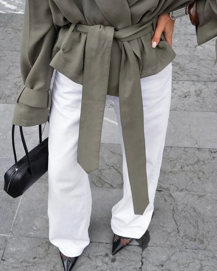 Women's olive green cropped trench coat displayed, highlighting its fashionable tie belt, notched lapel, and modern cut.