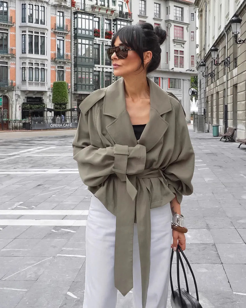 Elevate your style with this olive green women's cropped trench coat, complete with a tie belt & elegant notched lapel.