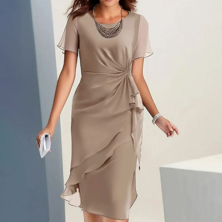 Woman elegantly walking in a formal midi dress with flutter sleeves & a charming ruffle hem.