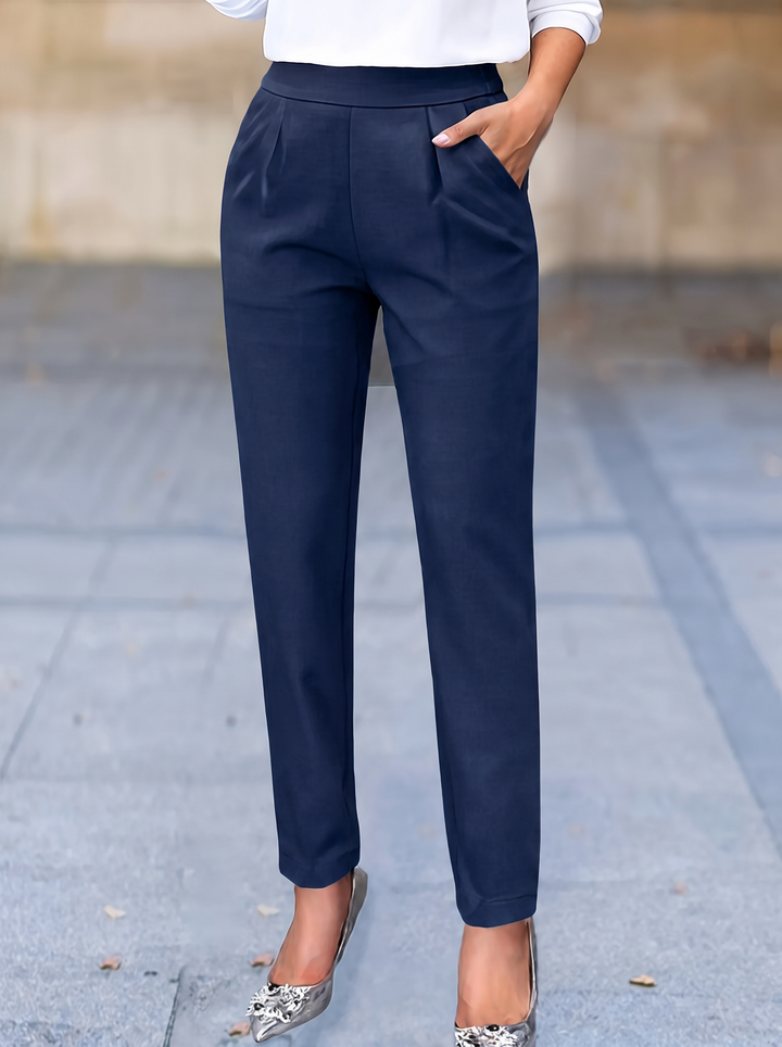 Comfortable women's work pants, high-waisted and pleated, designed with a functional tapered fit and pockets.