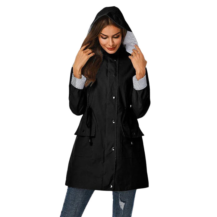 Versatile women's hooded rain jacket with snap front and long design for light rain protection. Coastal fashion.