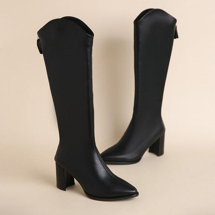 Posing in women's stylish block heel knee-high boots with a pointed toe & practical back zip.