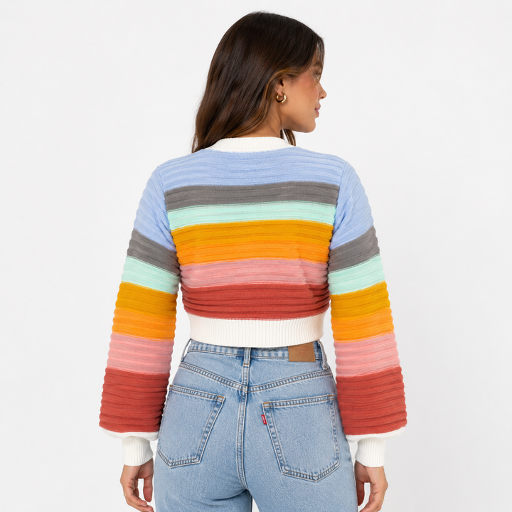 Pink women's V-neck cardigan featuring vibrant rainbow stripes and a button-up front.