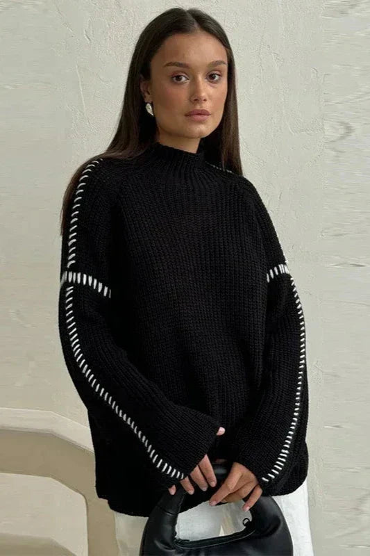 Stylish women's chunky knit jumper featuring an oversized fit, mock neck, and distinctive contrast stitch detail.