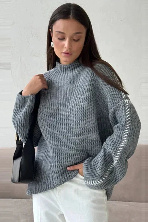 Women's long sleeve oversized chunky knit jumper. Cozy mock neck & stylish contrast stitch detail for winter.
