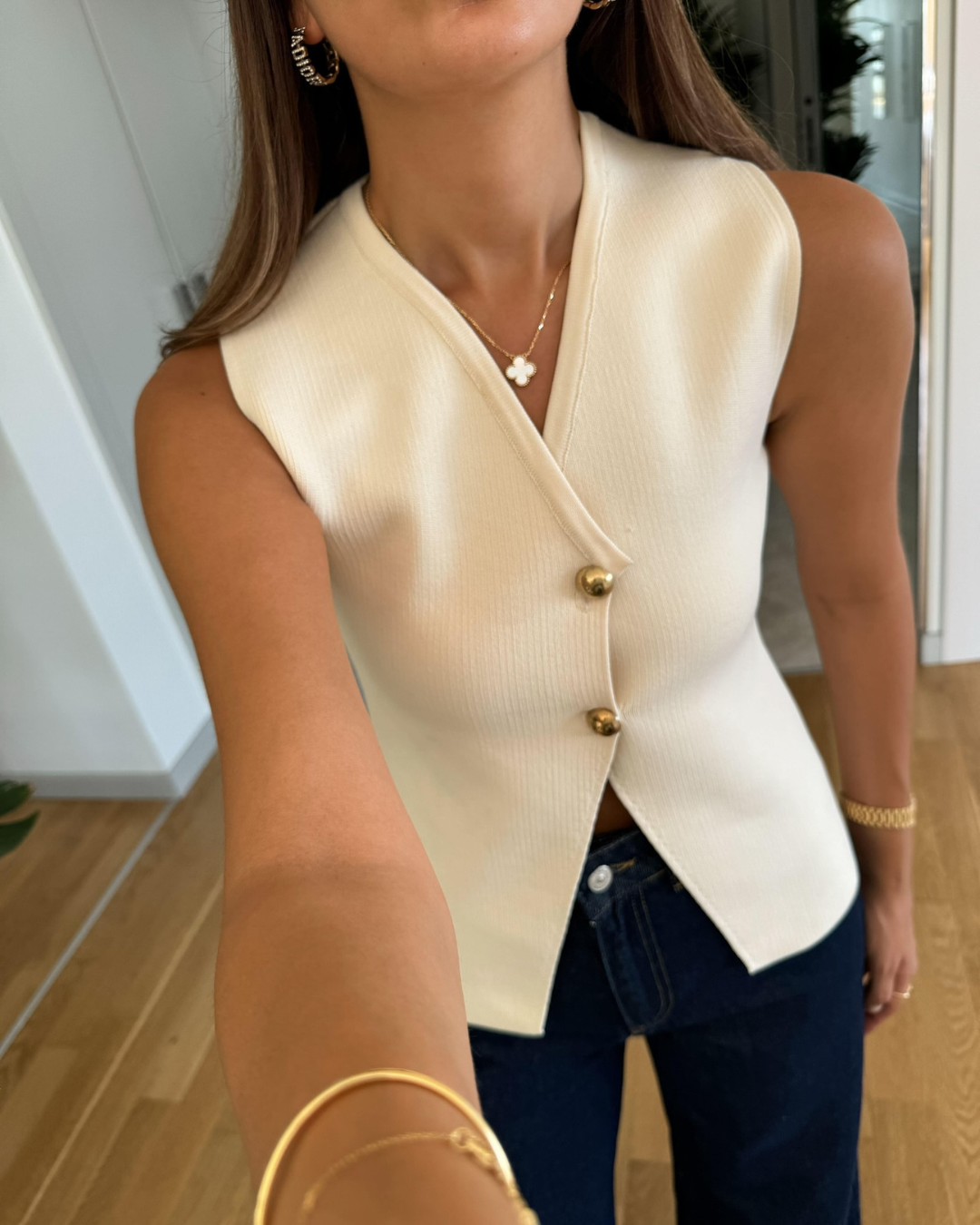 Knitted V-neck sleeveless top for women, featuring a chic button front. Great for layering and daily wear.