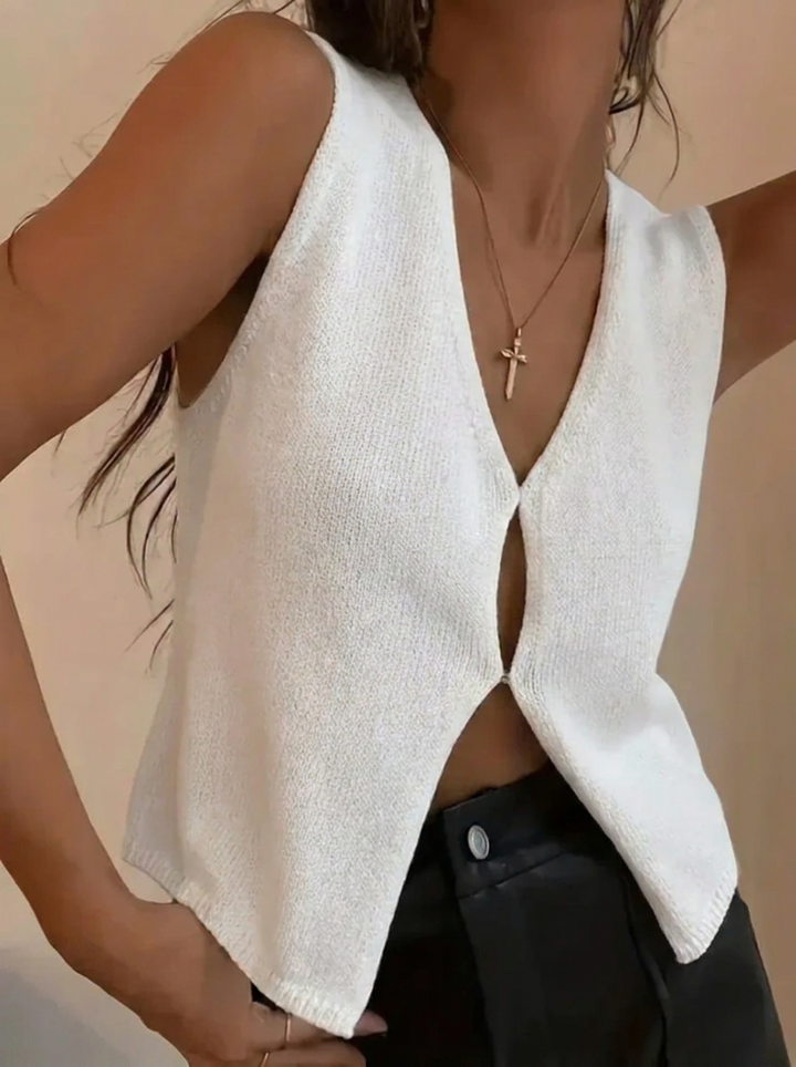 Women's deep V-neck sleeveless knitted vest top with sculpted hem. Modern, versatile layering piece.