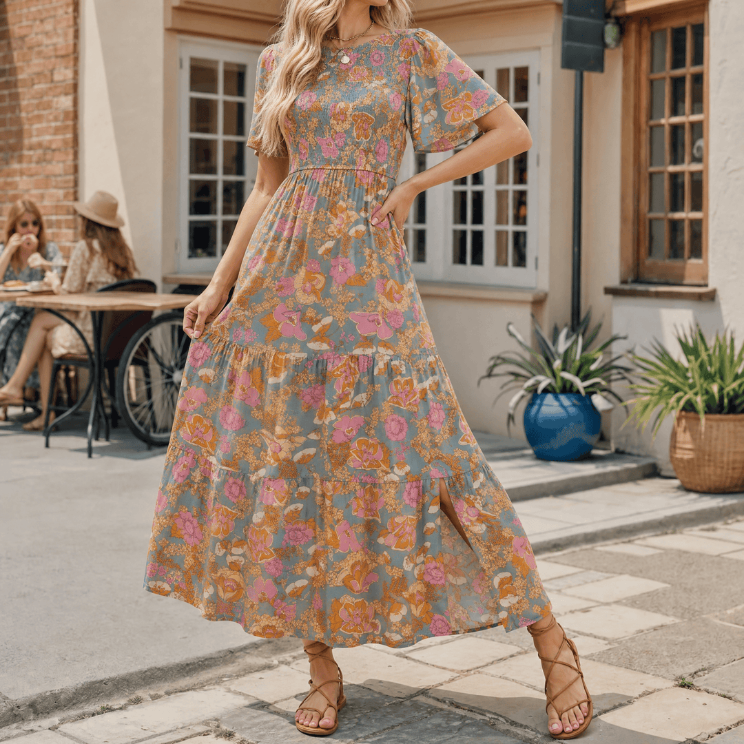 Women's smocked maxi dress with flutter sleeves, side slit, and flowy tiered skirt, perfect for summer.