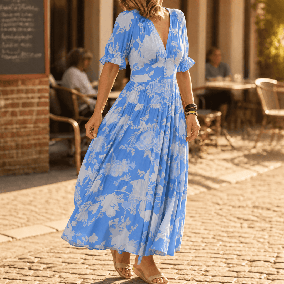 Feminine long floral V-neck maxi dress, tiered design & ruffle sleeves, for elegant spring/summer.